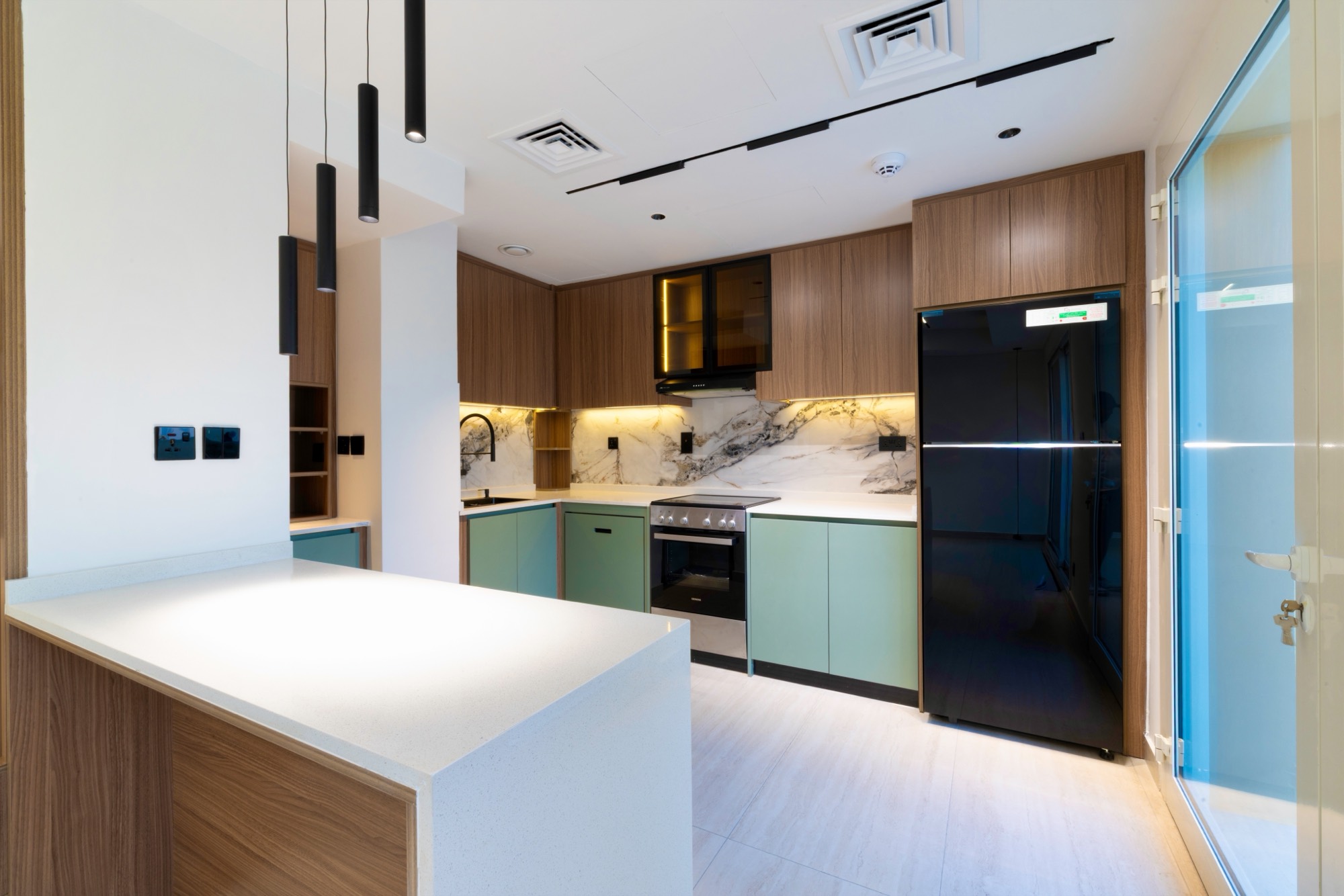 Kitchen island in white composite stone with black pendant lighting